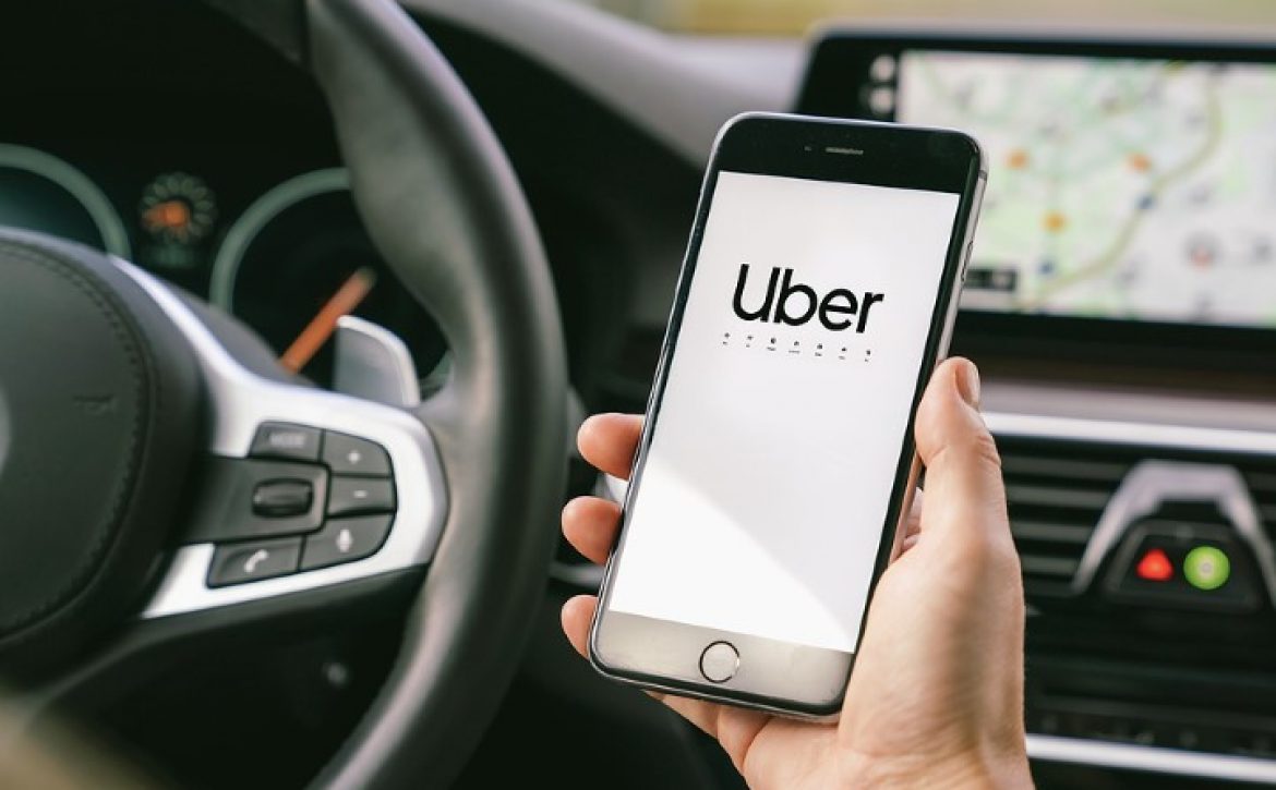 Uber Driver Holding Smartphone In Car. Uber Is An American Compa