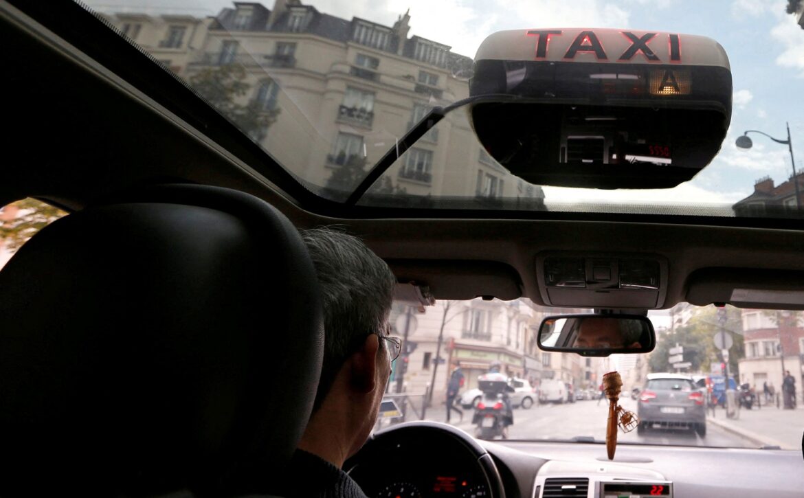 A taxi driver waits for passengers in Paris